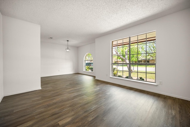 6516 Welch Ave, Fort Worth, TX 76133 - unfurnished room with dark wood-style flooring, a textured ceiling, baseboards, and a chandelier