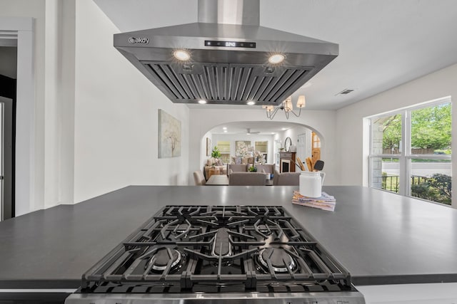 details with wall chimney range hood, dark countertops, arched walkways, and visible vents