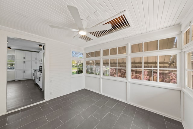 unfurnished sunroom featuring a ceiling fan
