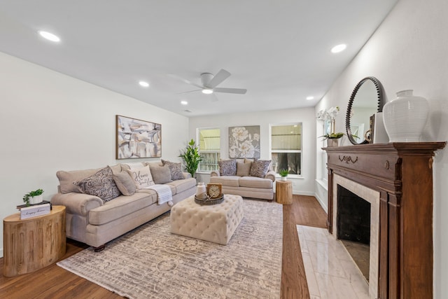 living area with a fireplace with flush hearth, light wood finished floors, a ceiling fan, and recessed lighting