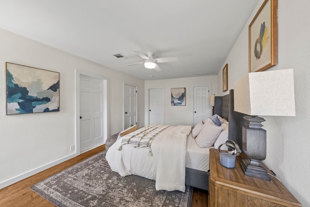 bedroom featuring wood finished floors, ceiling fan, baseboards, and visible vents