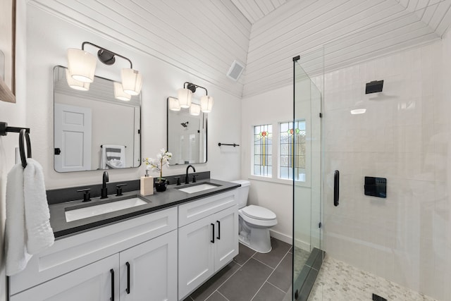 full bathroom with a shower stall, tile patterned floors, double vanity, and a sink