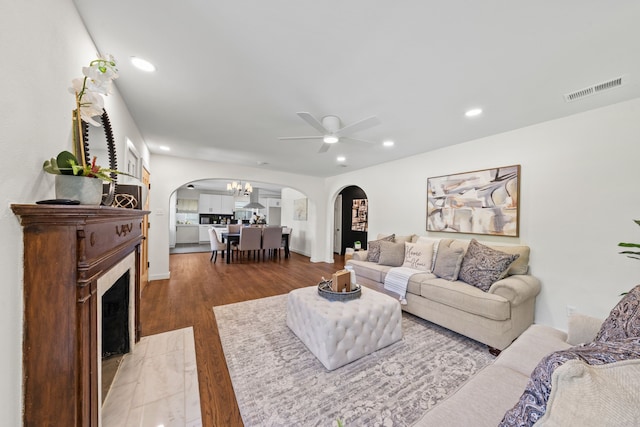living room featuring visible vents, arched walkways, recessed lighting, wood finished floors, and ceiling fan with notable chandelier