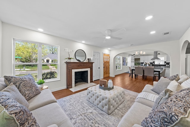 living room featuring arched walkways, wood finished floors, ceiling fan, and recessed lighting