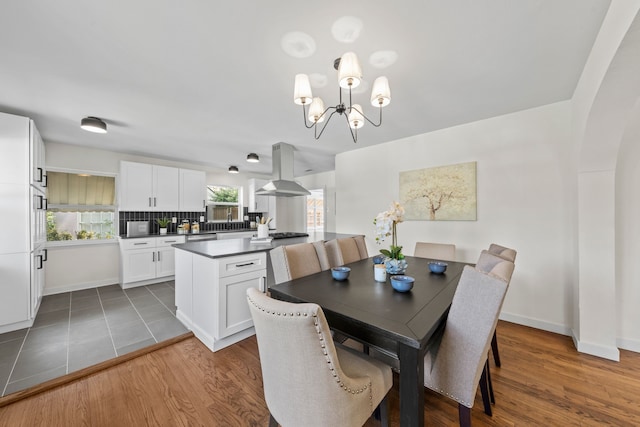 dining space featuring baseboards, a chandelier, and wood finished floors