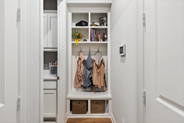 mudroom with a textured wall and wood finished floors