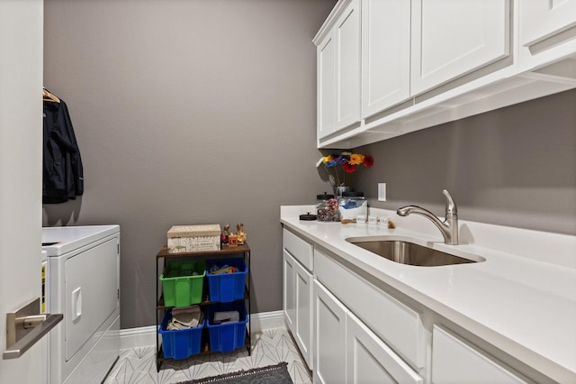 washroom with baseboards, cabinet space, a sink, and independent washer and dryer