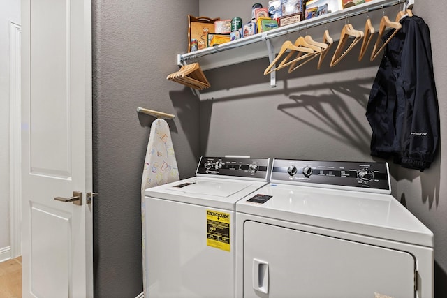 laundry room featuring wood finished floors, washing machine and clothes dryer, and laundry area