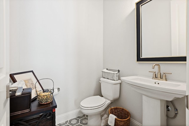bathroom featuring baseboards and toilet