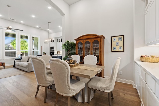 dining area featuring ceiling fan, arched walkways, wood finished floors, and recessed lighting