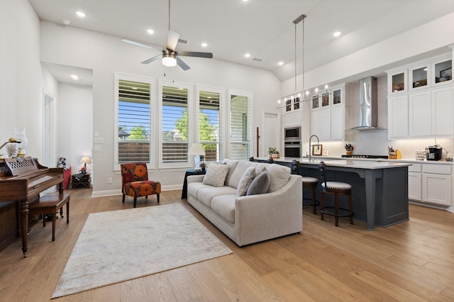 living area featuring light wood-type flooring, a ceiling fan, visible vents, and recessed lighting
