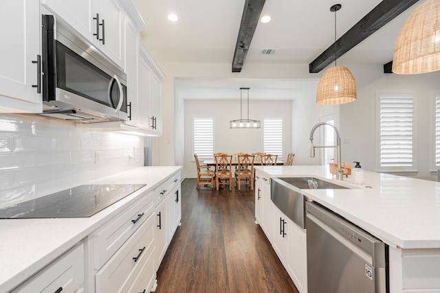 kitchen featuring beamed ceiling, dark wood finished floors, visible vents, a sink, and stainless steel appliances