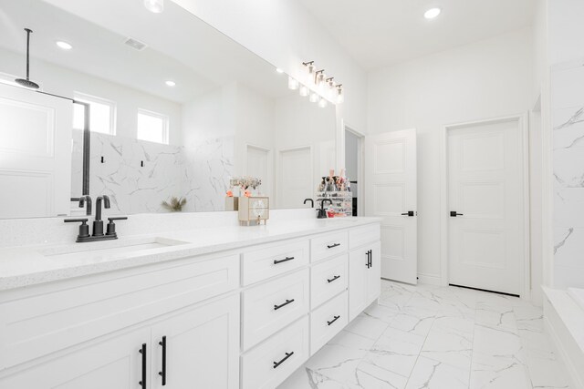 full bath featuring visible vents, a sink, double vanity, recessed lighting, and marble finish floor