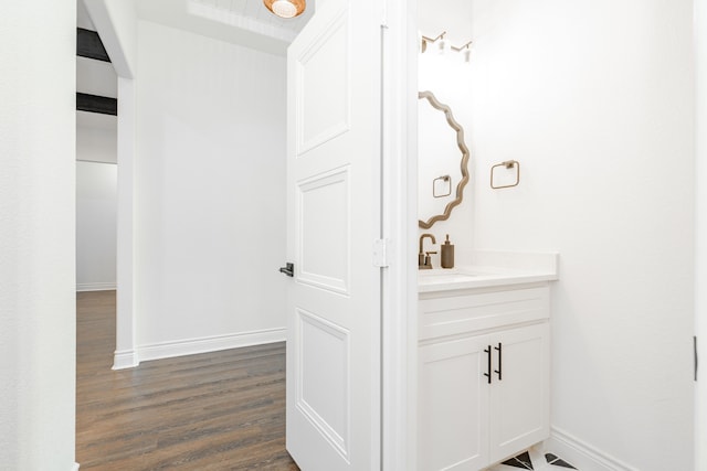 bathroom featuring wood finished floors, vanity, and baseboards