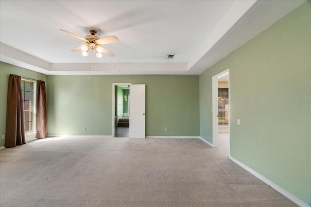 unfurnished room with a raised ceiling, baseboards, a ceiling fan, and carpet floors