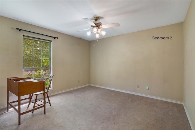 unfurnished office featuring carpet flooring, baseboards, and a ceiling fan