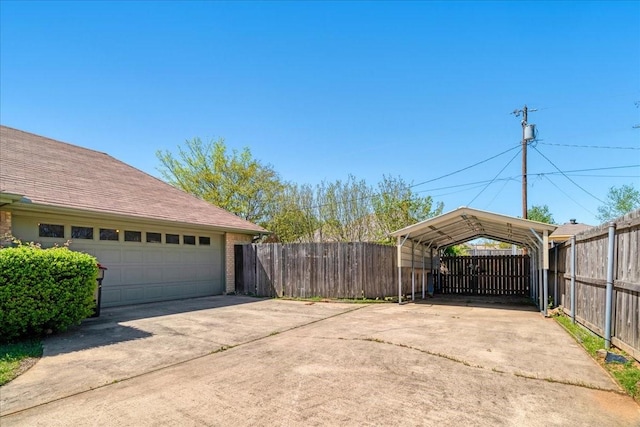 exterior space with a carport, concrete driveway, and fence