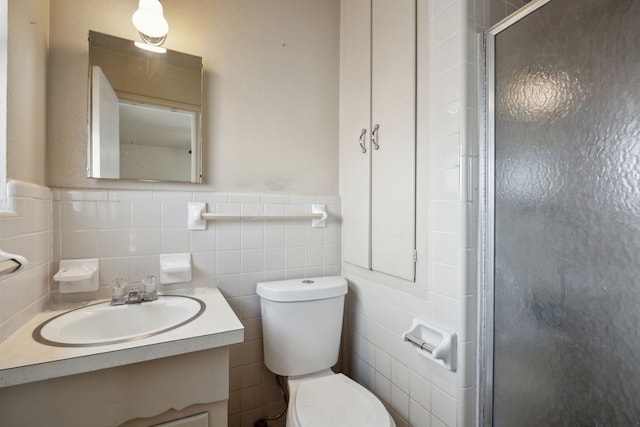 bathroom with toilet, tile walls, a shower stall, and vanity
