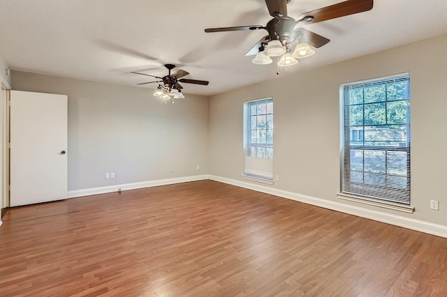 spare room with ceiling fan, baseboards, and wood finished floors
