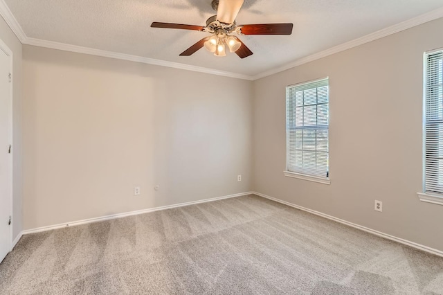 empty room featuring carpet flooring, a ceiling fan, crown molding, and baseboards