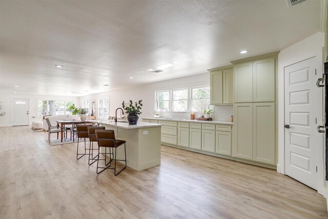 5440 Fursman Ave, Fort Worth, TX 76114 - kitchen with light wood-style flooring, a healthy amount of sunlight, and a kitchen breakfast bar