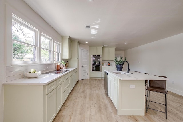 5440 Fursman Ave, Fort Worth, TX 76114 - kitchen with a sink, stainless steel appliances, light wood finished floors, backsplash, and visible vents