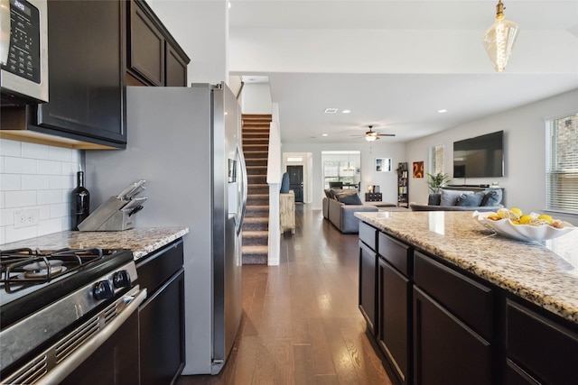 kitchen featuring stainless steel microwave, dark wood-type flooring, decorative backsplash, and a healthy amount of sunlight