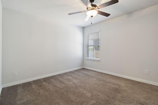 unfurnished room featuring dark colored carpet, baseboards, and a ceiling fan