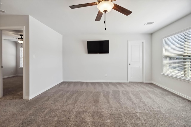 unfurnished room with visible vents, ceiling fan, carpet flooring, and baseboards