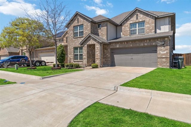 view of front of home with a front yard, brick siding, driveway, and an attached garage
