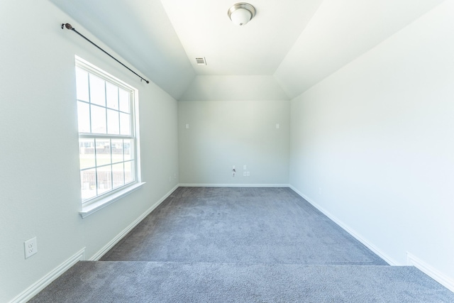 additional living space featuring carpet flooring, visible vents, baseboards, and vaulted ceiling
