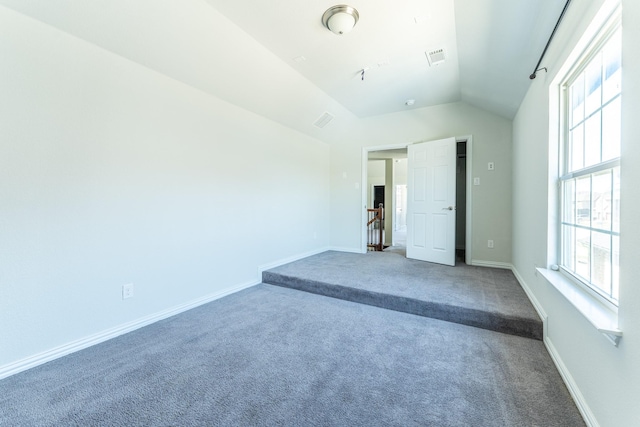 unfurnished bedroom featuring visible vents, baseboards, vaulted ceiling, and carpet floors