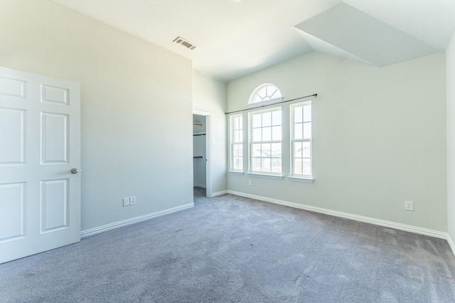 unfurnished bedroom with carpet flooring, baseboards, vaulted ceiling, and visible vents