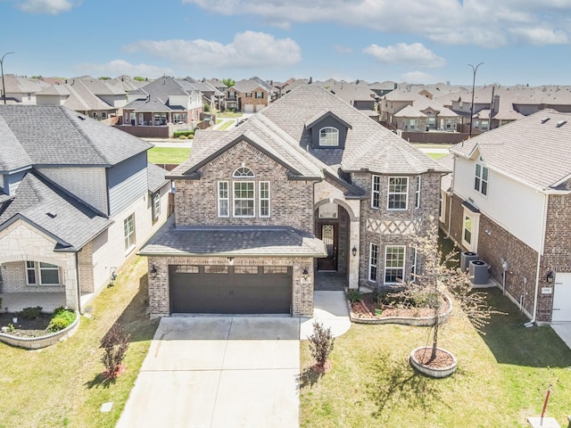 view of front of house with stone siding, driveway, a garage, and a residential view