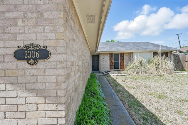 2306 Lavon Creek Ln, Arlington, TX 76006 - view of exterior entry with brick siding and a shingled roof