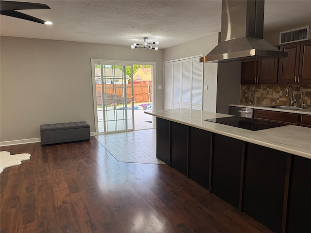 5540 Rutledge Dr, The Colony, TX 75056 - kitchen with black electric stovetop, a sink, visible vents, light countertops, and island exhaust hood
