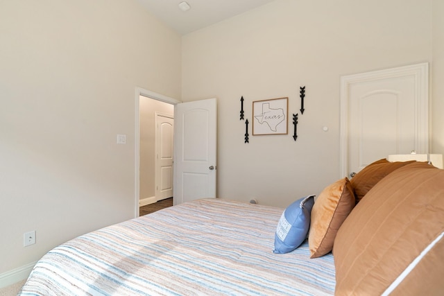 bedroom featuring a towering ceiling and baseboards