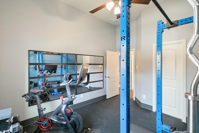 workout room with a towering ceiling, a ceiling fan, and baseboards