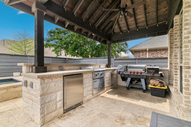 view of patio featuring a gazebo, grilling area, ceiling fan, an outdoor kitchen, and fence