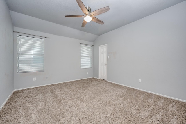 carpeted empty room featuring baseboards, ceiling fan, and lofted ceiling