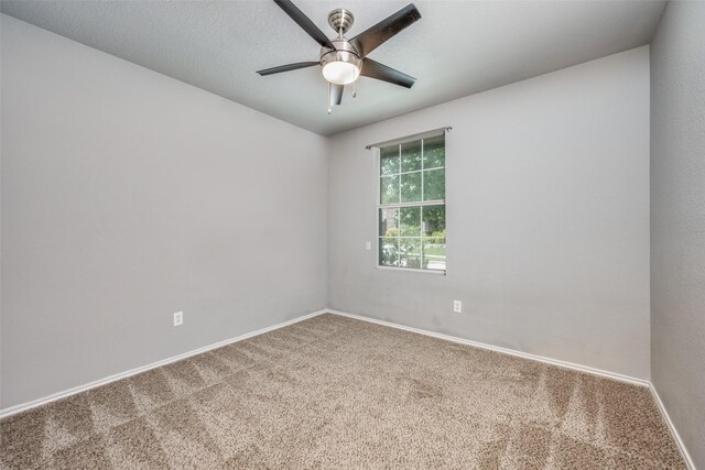 spare room featuring carpet floors, a ceiling fan, and baseboards