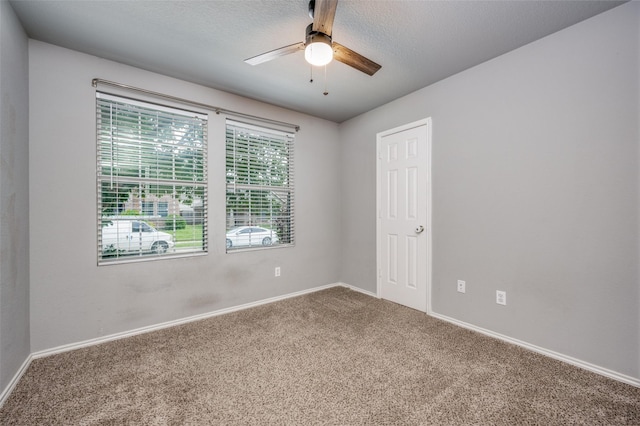 carpeted empty room featuring baseboards, a ceiling fan, and a textured ceiling