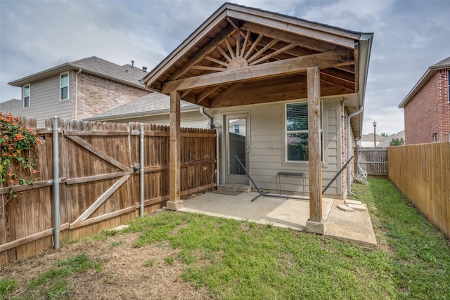 rear view of property featuring a fenced backyard, a patio, and a yard