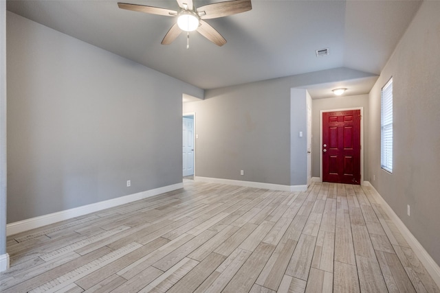 unfurnished room featuring ceiling fan, visible vents, baseboards, lofted ceiling, and light wood-style flooring