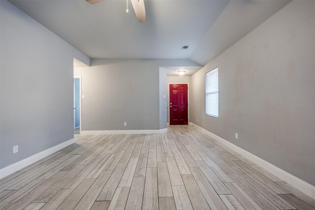 spare room with ceiling fan, visible vents, baseboards, lofted ceiling, and light wood-style floors