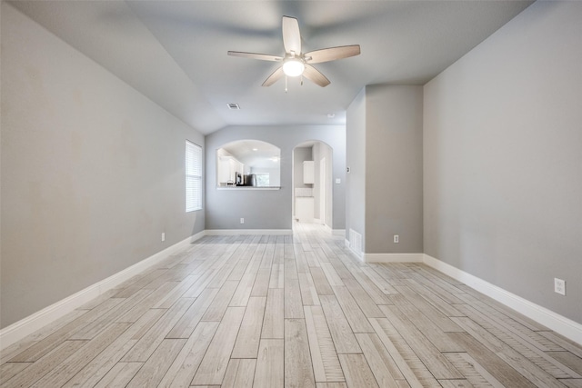 spare room with arched walkways, ceiling fan, visible vents, and light wood-style flooring