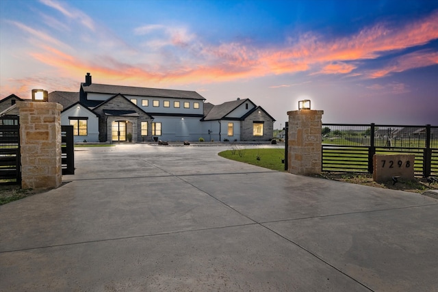 view of front of house featuring fence private yard, a chimney, and curved driveway