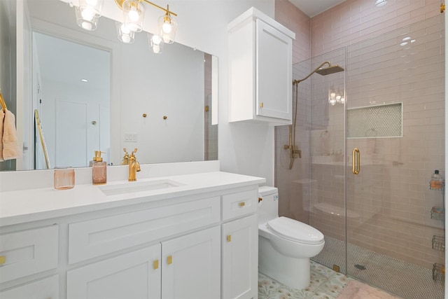 bathroom with toilet, vanity, and a stall shower