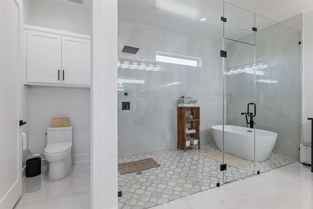 full bath with toilet, a freestanding tub, and a stall shower