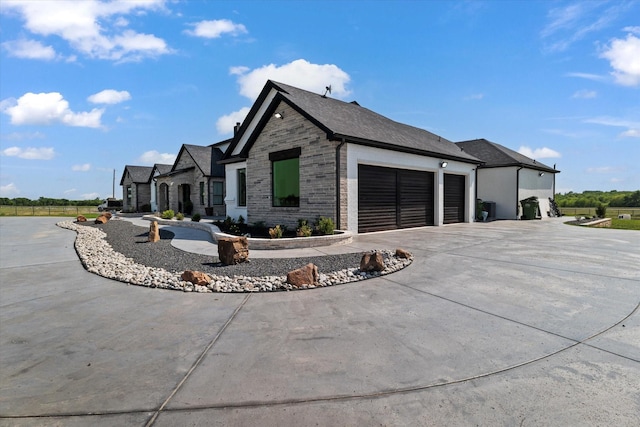 view of side of home featuring concrete driveway and an attached garage